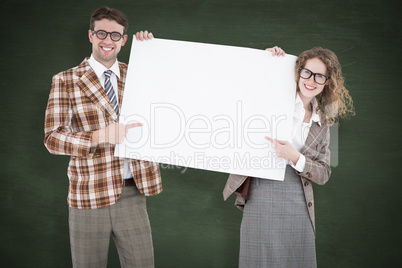 Composite image of geeky hipster couple holding poster