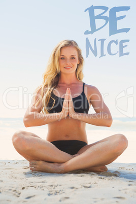Composite image of fit blonde sitting in lotus pose on the beach