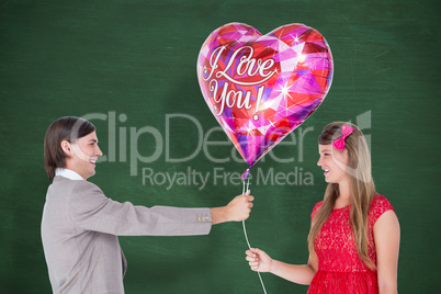 Composite image of geeky hipster offering red heart shape balloo