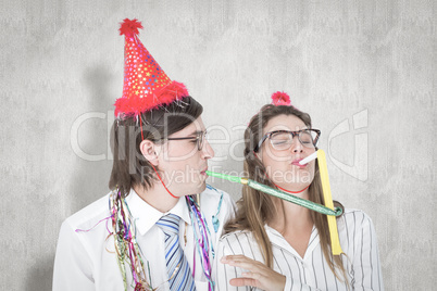 Composite image of geeky hipster wearing a party hat with blowin