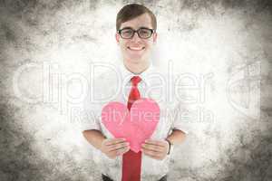 Composite image of geeky hipster holding heart card