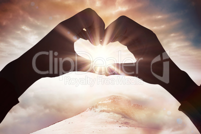 Composite image of woman making heart shape with hands
