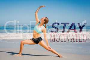 Composite image of fit woman standing on the beach in warrior po