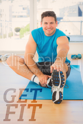 Composite image of sporty man stretching hand to leg in fitness