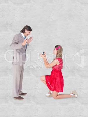 Composite image of pretty hipster on bended knee doing a marriag