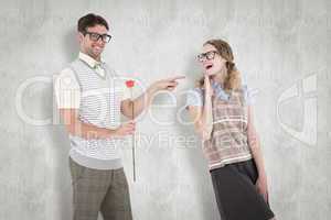 Composite image of geeky hipster holding rose and pointing his g