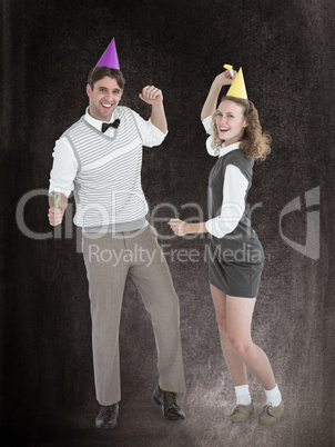 Composite image of geeky couple dancing with party hat