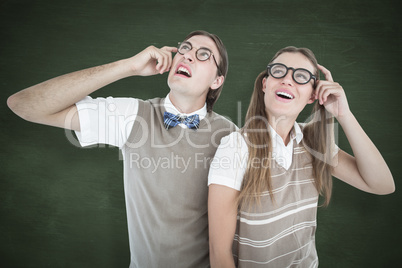 Composite image of geeky hipsters looking confused