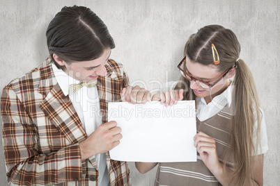 Composite image of geeky hipsters holding a poster Composite image of geeky hipsters holding a poster