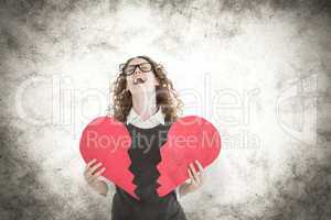 Composite image of geeky hipster holding a broken heart card