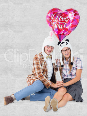 Composite image of geeky hipster in love couple looking at camer