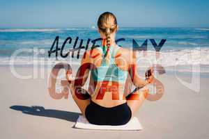 Composite image of fit woman sitting on the beach in lotus pose