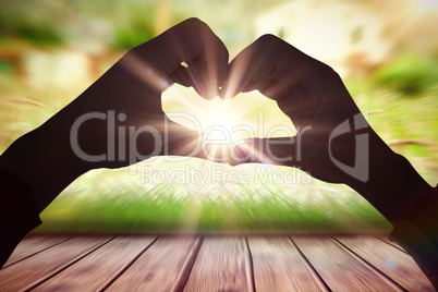 Composite image of woman making heart shape with hands