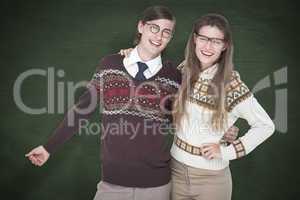 Composite image of happy geeky hipster couple embracing