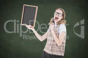 Composite image of geeky hipster woman holding blackboard and si