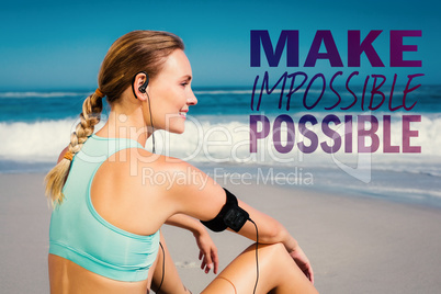 Composite image of fit woman sitting on the beach taking a break