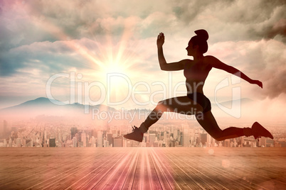 Composite image of fit brunette running and jumping