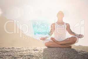 Composite image of blonde woman sitting in lotus pose on beach