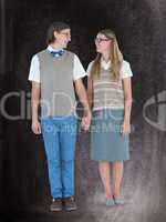 Composite image of geeky hipster couple holding hands and lookin