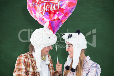 Composite image of geeky hipster in love couple looking at each