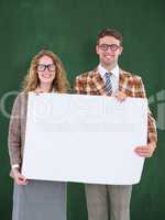 Composite image of geeky hipster couple holding poster