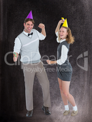 Composite image of geeky couple dancing with party hat