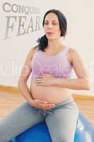 Composite image of pregnant brunette sitting on exercise ball br