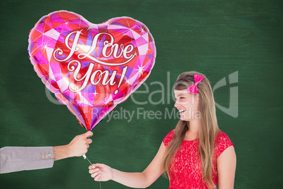 Composite image of geeky hipster offering red heart shape balloo