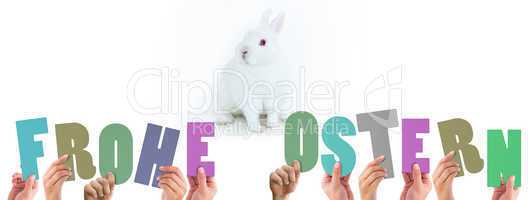 Composite image of hands holding up frohe ostern