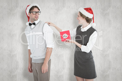 Composite image of geeky hipster offering present to her boyfrie