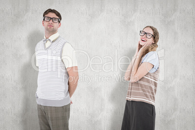 Composite image of geeky hipster couple looking at camera