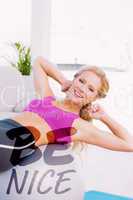 Composite image of smiling fit blonde doing sit ups with exercis