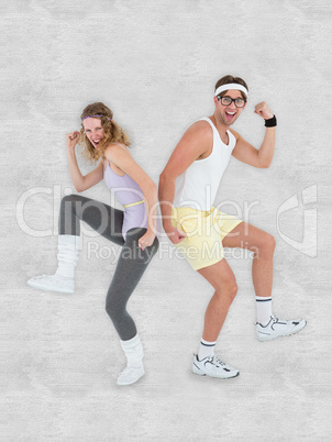Composite image of geeky hipster couple posing in sportswear