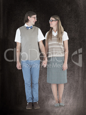 Composite image of geeky hipster couple holding hands and lookin