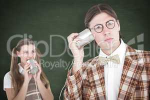 Composite image of geeky hipsters using string phone