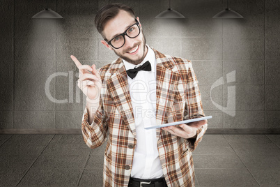 Composite image of geeky hipster holding a tablet pc