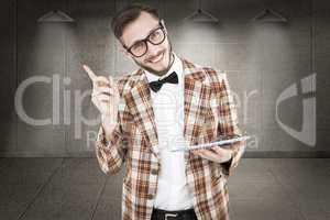 Composite image of geeky hipster holding a tablet pc