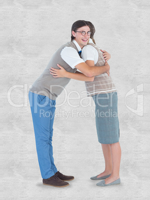 Composite image of geeky hipster couple hugging