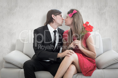 Composite image of cute geeky couple kissing