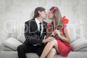 Composite image of cute geeky couple kissing