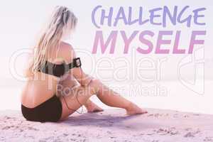 Composite image of fit blonde sitting in on the beach taking a b