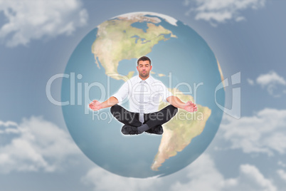 Composite image of businessman meditating in lotus pose