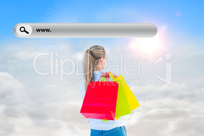 Composite image of pretty blonde holding shopping bags