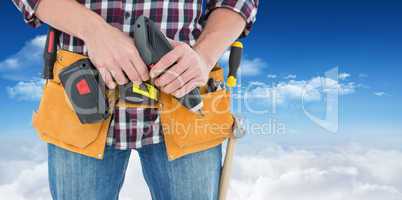 Composite image of male repairman holding drill machine