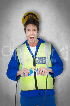 Composite image of electrician getting a shock while holding wir
