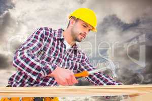 Composite image of handyman using hammer on wood