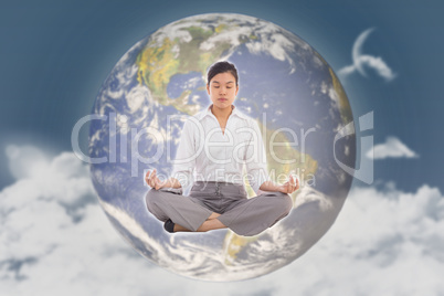 Composite image of businesswoman sitting in lotus pose