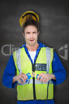 Composite image of electrician getting a shock while holding cab
