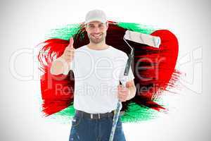 Composite image of happy man with paint roller gesturing thumbs