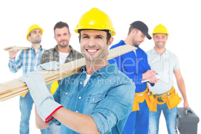 Composite image of happy carpenter carrying wooden planks